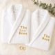 Set de doua halate albe personalizate pentru cuplu, brodate cu text auriu The Real Boss si The Boss, cu verighete decorative si eucalipt.